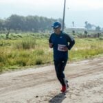 Middle-aged man in sportswear jogging on a rural dirt path