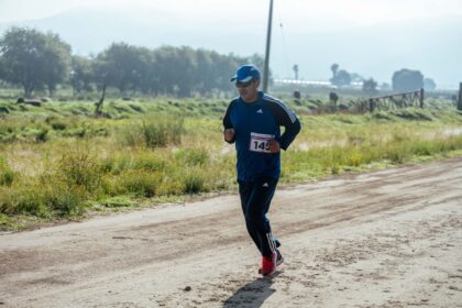 Middle-aged man in sportswear jogging on a rural dirt path
