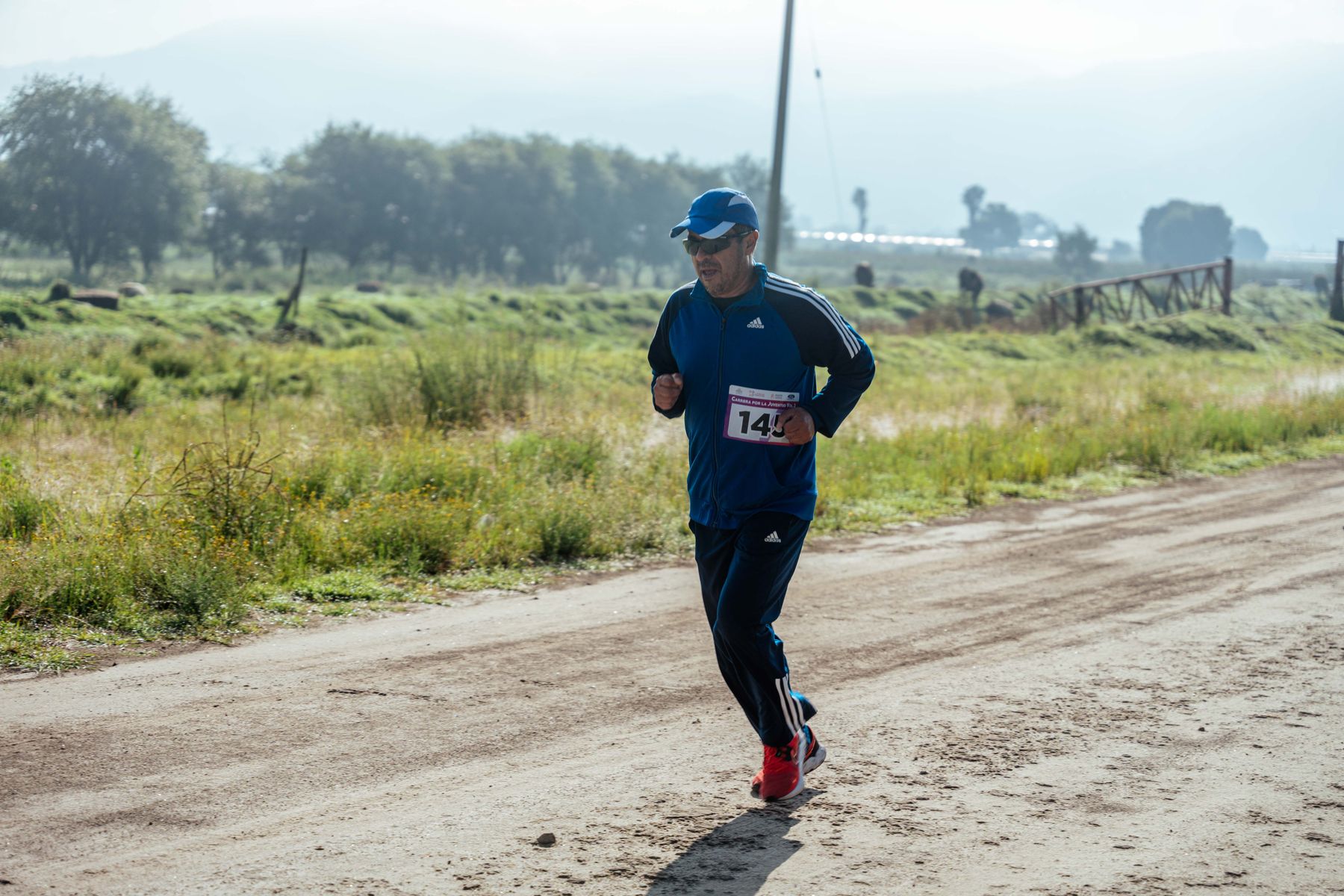 Middle-aged man in sportswear jogging on a rural dirt path