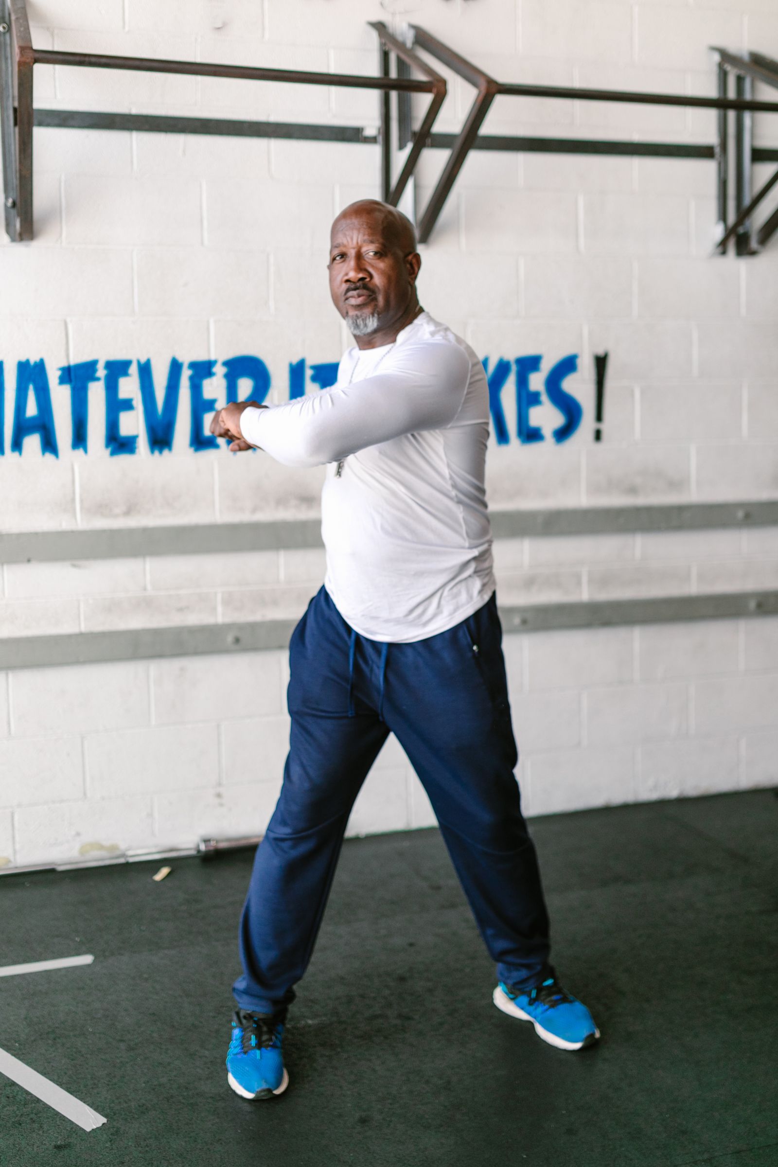 Man warming up with a stretch in a gym