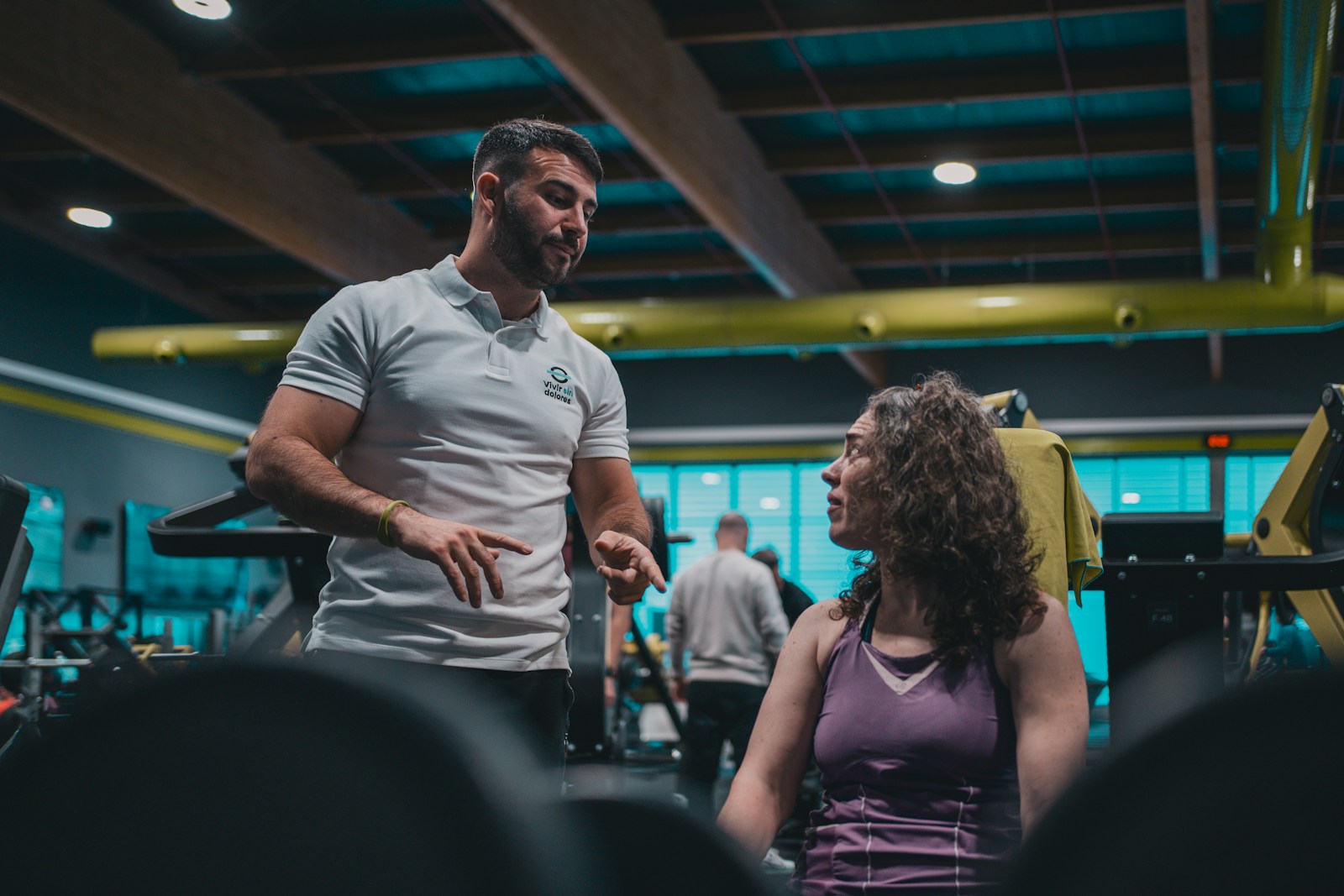 Illustrative photograph of a woman talking with her personal trainer in a gym
