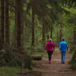 Middle-aged couple walking together on a green forest trail