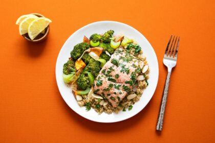 Salmon fillet with herbs on quinoa beside roasted broccoli